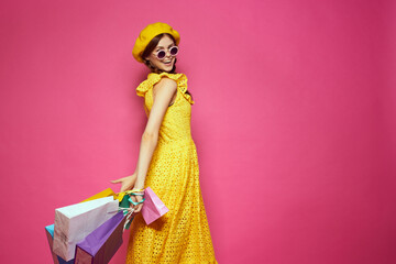 glamorous woman in a yellow hat Shopaholic fashion style pink background