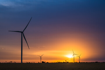 Fototapeta na wymiar Wind turbines at dawn. Picturesque view of the wind power generator. Production of environmentally friendly energy.