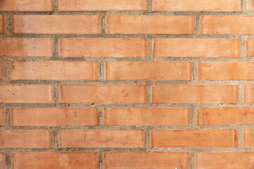 Wall made of red bricks, suitable as background or wallpaper pattern.