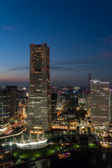 Obraz premium Vertical image of Yokohama Minato Mirai 21 seaside urban area in central Yokohama with Landmark tower at Magic hour