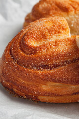 Food photo composition. Fresh white bread bun with sugar on a gray background. Nearby is a glass of milk.