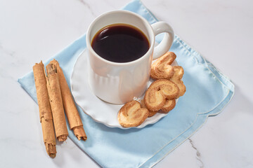 Puff. Flaky sugar Palmiers cookies in a ceramic plate on a light background. Sweet homemade