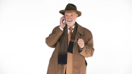 Elderly man in hat talking on cellphone isolated on white background. 