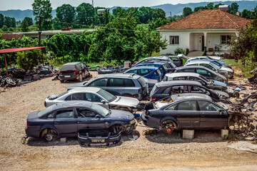 Auto demolition for recycling or destruction in the countryside in Albania. Many old wrecked cars among green nature