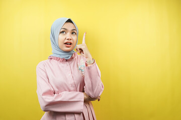 Beautiful young muslim woman getting idea, pointing up, isolated