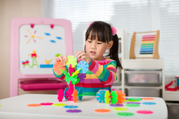 young irl playing creative toy blocks at home