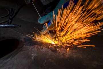 MMA welding. Welding with an electrode close-up. A welder welds large diameter pipes with manual...
