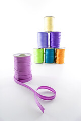 rolls with multi-colored decorative ribbons for clothes on a white background
