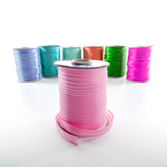 rolls with multi-colored decorative ribbons for clothes on a white background