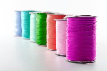 rolls with multi-colored ribbons for clothes on a white background