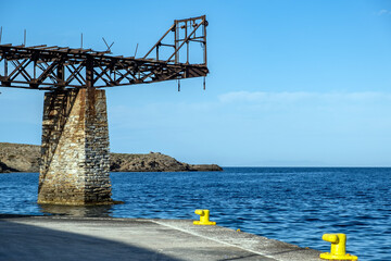 Old rusty mine iron bridge at Loutra port Kythnos island Cyclades summer destination Greece.