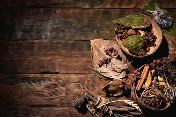 Witchcraft flat lay concept background with copy space. Herbs and dry plants on the brown wooden table background.