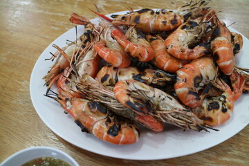 Many grilled shrimps on a white plate