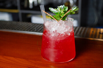 Red alcoholic cocktail on a bar counter in a bar. 