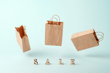 Flying paper shopping bags and the word sale on a blue background.The concept of delivery of...