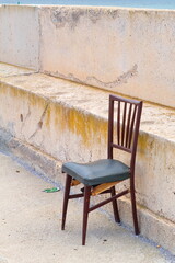 A deteriorated and isolated chair inside the fishing port