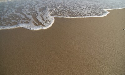 The waves crashed into the secluded sandy beach.