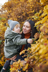 beautiful woman with a baby in her arms. in the park