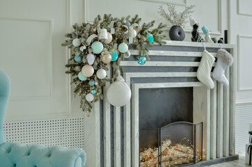 A beautiful New Year's interior with a large, decorated with toys standing near the fireplace.