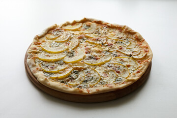 Pizza with cheese and pear fruit on cutting board