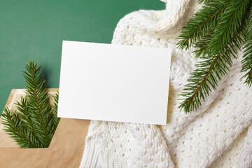 Christmas greeting card mockup with fir tree branches on knitted background
