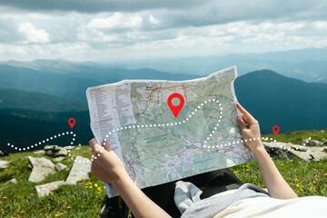 Fototapeta Young woman hiker reading map hiking trip looking to find place to go obraz