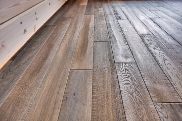 Close-up of natural wood parquet floor room with wooden walls in country house