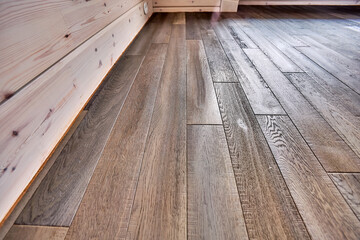 Close-up of natural wood parquet floor room with wooden walls in country house