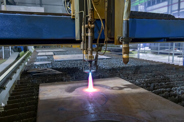 Gas cutting of sheet steel on a machine with numerical control. Splashes of molten metal.