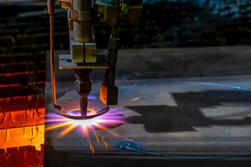 Gas cutting of sheet steel on a machine with numerical control. Splashes of molten metal.