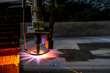 Gas cutting of sheet steel on a machine with numerical control. Splashes of molten metal.