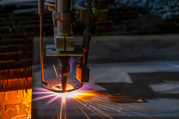 Gas cutting of sheet steel on a machine with numerical control. Splashes of molten metal.