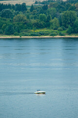 a small ship sails along the Volga River