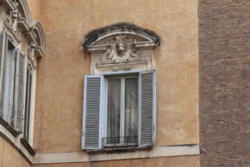 Window with Grey Shutters and Sculpted Lion Detail in the Monti District in Rome, Italy