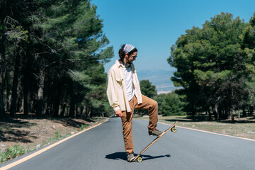 Hipster boy standing in the street on his skateboard © Luis