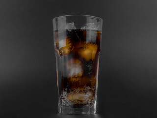 glass of cola with Ice Cubes on black background