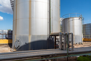 Pipes with insulators to preserve the heat of the liquids next to tanks for storage.