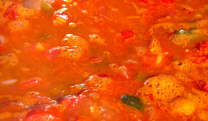 Boiling pear tomato with pieces of red and green pepper, onion, garlic, zucchini and eggplant. Blanching to prepare canning jars. La Rioja, Spain.