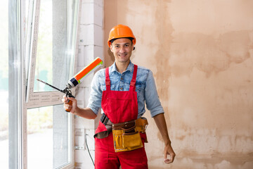 Man worker mounting window in a renovated building
