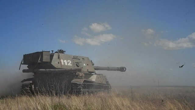 Close View Heavily Armed Combat Artillery Vehicle Shooting in Sand. Military Army Tank Shooting Side View. War Battle Technology Concept. Ground Shot Footage
