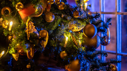 Christmas and New Year interior decoration. Green tree decorated with toys, flashing garland, illuminated lamps. Xmas tree. Cozy Christmas atmosphere