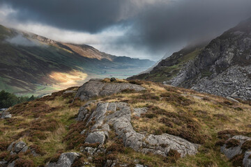 Epic Autumn landscape image of view along Nant Fracon valley in Snowdonia National Park with dramatic evening sky and copy space