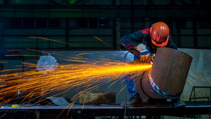 Manufacturing of steel pipes in one of the plant's workshops. Rotation of the angle grinder disc...