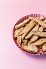 Biscotti with nuts on pink background. Delicious cantucci cookies. Cantuccini. Traditional italian homemade dry crispy biscuits.