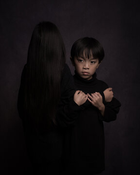 Fine art studio portait of asian brother and sister in black showing love and hands