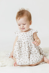 little girl in a light dress on a light background