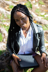 beautiful african student smiling sitting in a park