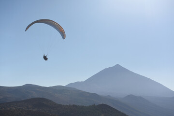 Paraglider flying in the blue sky with Mount Teide at the background.Tenerife, Canary Islands, Spain.