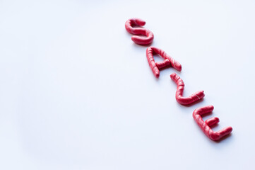 the word sale is made of red plasticine with white flecks on a white background, written diagonally with space for the text and blurred extreme letters