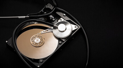 Internal parts of the hard drive. HDD. Computer memory. Modern technologies. Computer repair. Data storage concept. Black background. A stethoscope near the hard drive.